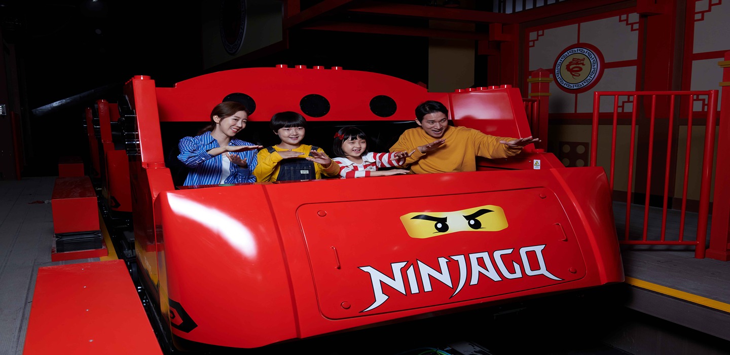 Family of four on sittin in the Red Ninjago themed rollercoaster car