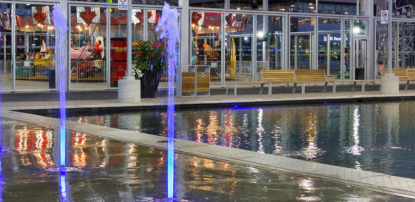 downsview parkette pool with two fountains shooting water vertically with big glass windows behind looking inside i