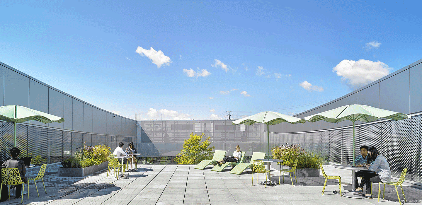 Grey concrete roof top patio with green lounge chairs, green umbrellas and people sitting on green chairs at Vaughan Civic Centre