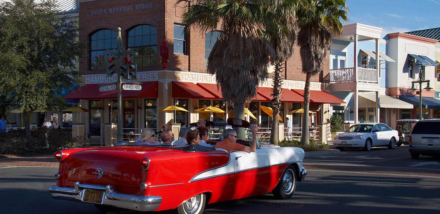 People riding in old red convertible on the roads of The Villages