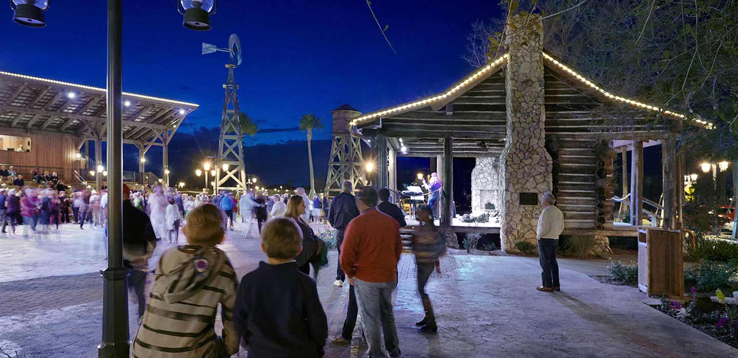 The Villages at night with people gathering