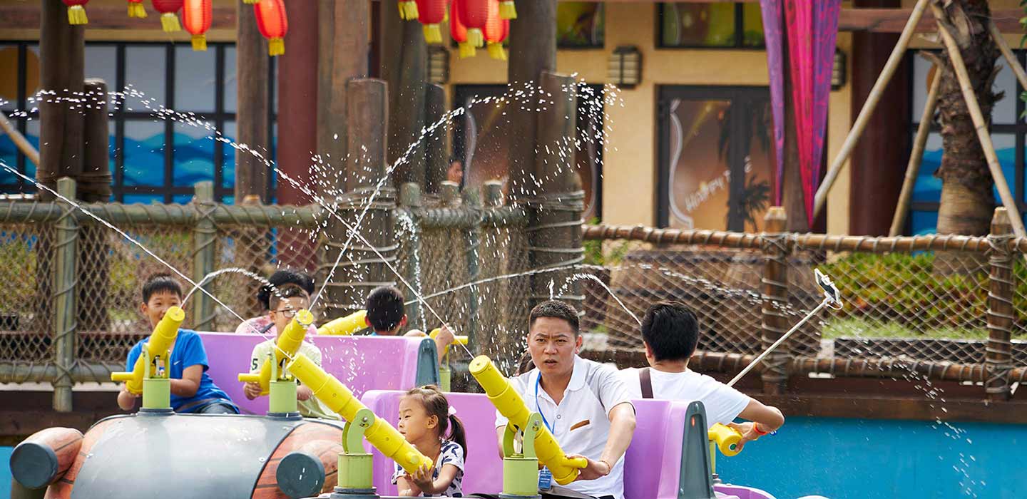 People enjoying shooting water out of water gun ride at Wanda Xishuangbanna Theme Park